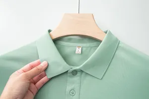 Detail shot of mint green polo shirt collar showing fabric texture and size label