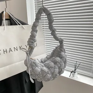 Close-up of grey puffy bubble cloud bag with unique pleated texture and crescent shape.