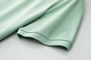 Close-up view of the breathable light green pique polo shirt sleeve with ribbed cuff detail