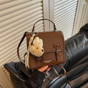 Fashionable brown woven leather backpack for women featuring a cute plush bear charm