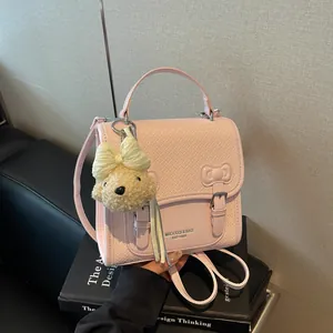 Stylish pink woven school style backpack with a cute bear charm and bow detail for women