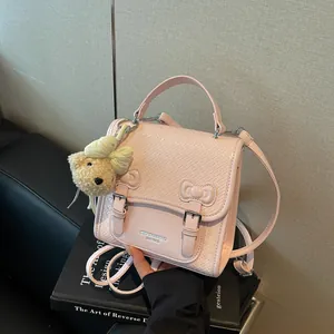 Pink college style woven backpack with bow detail and cute teddy bear charm accessory