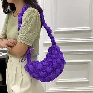Stylish purple quilted popcorn cloud bag displayed on a model in a casual setting