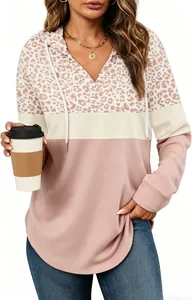 Close-up view of a leopard print patchwork hoodie with V-neck and drawstring detail.
