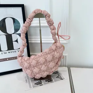 Detailed view of a pink quilted bubble shoulder bag featuring a stylish ruched strap design