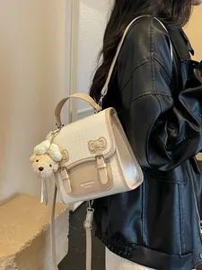 Fashionable cream woven backpack for women with tan accents and cute bear charm
