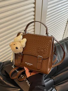 Chic brown woven college style backpack for women featuring a cute teddy bear charm accessory