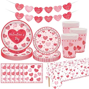 Pink Valentine's Day party tableware set with heart-patterned plates, cups, and napkins