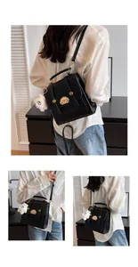 Vue détaillée d'un sac à dos vintage noir élégant avec un joli charme d'ours en peluche blanc