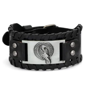 Dettaglio del totem del corvo di Odino su un ampio bracciale vichingo in pelle nera vintage.