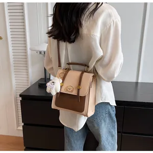 Sac à dos vintage beige et marron porté par un modèle dans un intérieur moderne