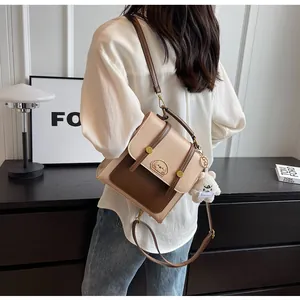 Vue détaillée d'un petit sac à dos bicolore vintage avec charm ours mignon