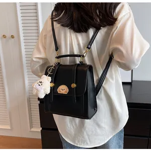 Vue arrière d'un sac à dos noir élégant avec écusson chien et porte-clés en peluche.