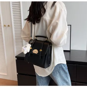 Femme portant un sac à dos vintage noir avec un charm ours mignon dans un décor