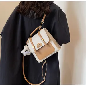 Vue détaillée d'un sac à dos vintage crème et beige avec une broderie de chiot mignon.