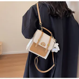 Vue arrière élégante d'un sac à dos bicolore vintage avec un ours en peluche mignon
