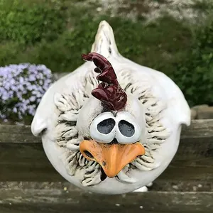 Detailed view of a funny big-eyed resin chicken ornament for garden fence decoration