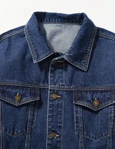 Close-up detail of a dark blue denim jacket showing collar and buttoned pockets