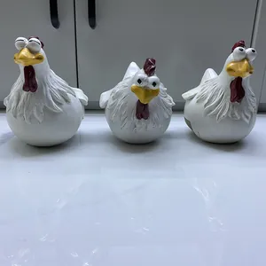 Close-up detail of three comical resin rooster figurines with big eyes for garden decor
