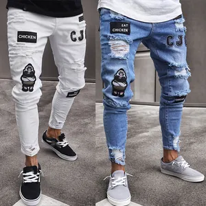 Detailed view of men's distressed skinny jeans in white and blue with unique patches