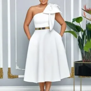Elegante abito midi bianco monospalla con un grande fiocco sulla spalla e cintura dorata