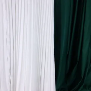 Close-up detail of white fine pleats and dark green draped fabric texture