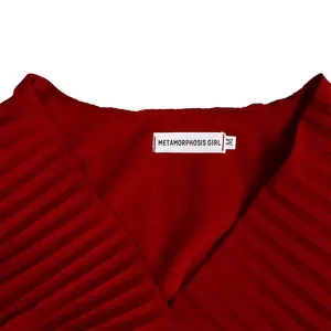Close-up detail of a red pleated V-neck maxi dress showing brand label and texture