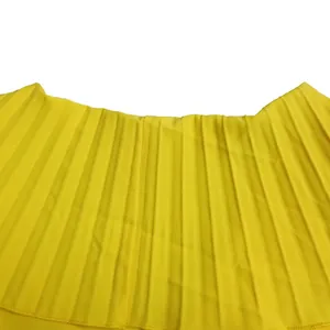 Close-up detail of vibrant yellow pleated fabric showing fine accordion folds on the dress