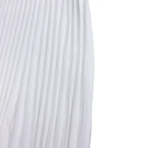 Detailed view of the elegant fine accordion pleats on a white fashion maxi dress texture