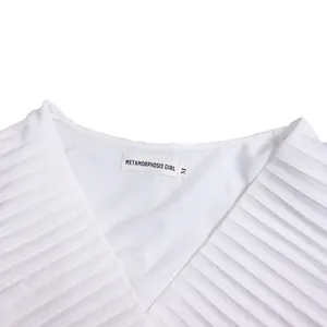Macro view showing the elegant pleated texture and neckline of the white summer dress