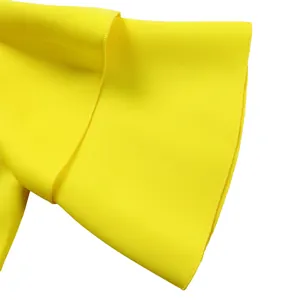 Detailweergave van de felgele dubbellaagse ruffelmouwen op de jurk.