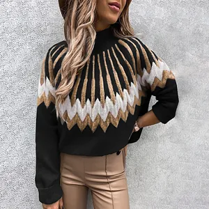 Detail of a women's black knit sweater with a white and tan geometric sunburst pattern
