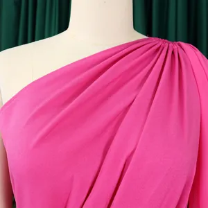 Macro detail of the elegant pink one-shoulder jumpsuit with shoulder pleat accents