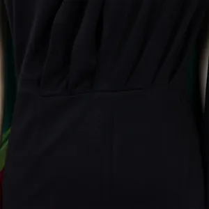 Detailed close-up showing the exquisite pleated fabric and waist design of a black evening jumpsuit