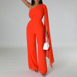 Detailed view of the elegant orange one-shoulder jumpsuit with a long flowing side cape