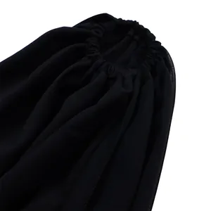 Close-up detail of black jumpsuit showing elasticated hem and fine textured fabric