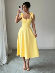 Elegante heldergele midi-jurk met decoratieve schouderstrikjes en een hartvormige halslijn