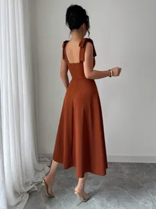 Elegante roestkleurige maxi-jurk met stijlvolle strikschouderbandjes en detail van achterkant.