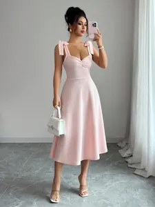 Elegante roze midi-jurk met knoopbandjes en een hartvormige halslijn getoond op een model