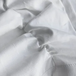 Primer plano macro detallado de tela blanca fruncida de falda con textura de sarga y costuras.