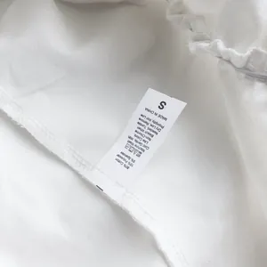 Detalle de la etiqueta de lavado de la falda blanca con composición e instrucciones de cuidado