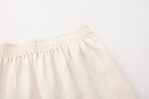 Gedetailleerde macro-opname van de hoge elastische tailleband op een crème linnen rok
