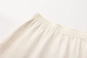 Detail van de elastische tailleband van een crème katoenen linnen rok.