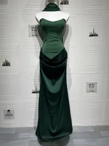 Elegant emerald green satin strapless gown with draped detail on mannequin