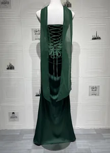 Back view of a dark green satin evening gown with lace-up detail and streamers.