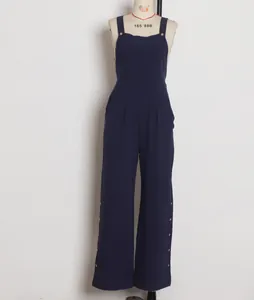 Dettaglio frontale di una tuta smanicata blu navy a gamba larga esposta su un manichino