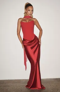 Elegant red strapless evening gown featuring a draped satin skirt and matching neck ribbon