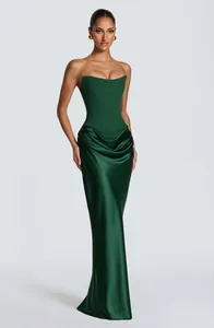 Elegant dark green strapless evening gown with a structured corset and draped satin skirt.