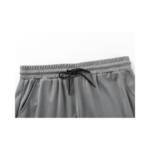 Detailansicht graue Mesh-Sportshorts mit elastischem Bund und schwarzem Kordelzug