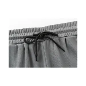 Detail von elastischem Bund und schwarzem Kordelzug an grauen Herren-Sportshorts
